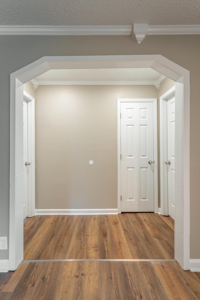 corridor featuring wood-type flooring and ornamental molding