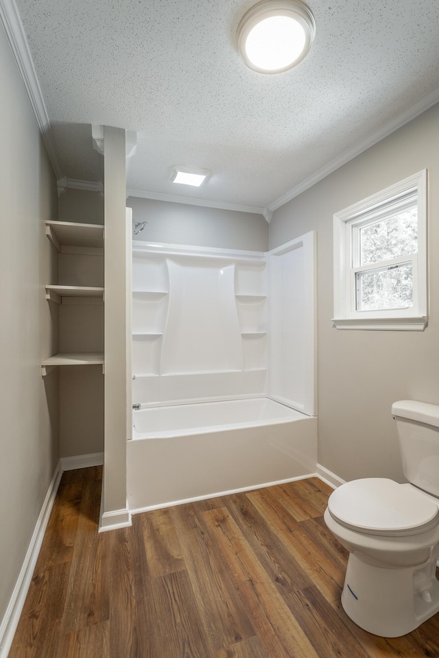 bathroom featuring shower / bathing tub combination, wood-type flooring, ornamental molding, a textured ceiling, and toilet