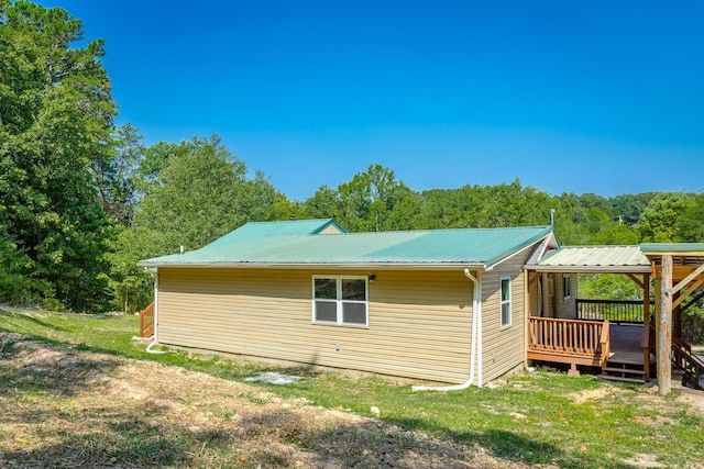 view of property exterior featuring a wooden deck and a yard