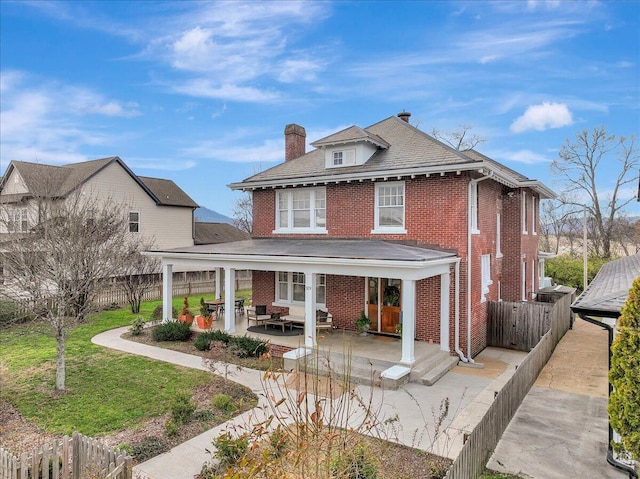 rear view of house with a patio area and a lawn