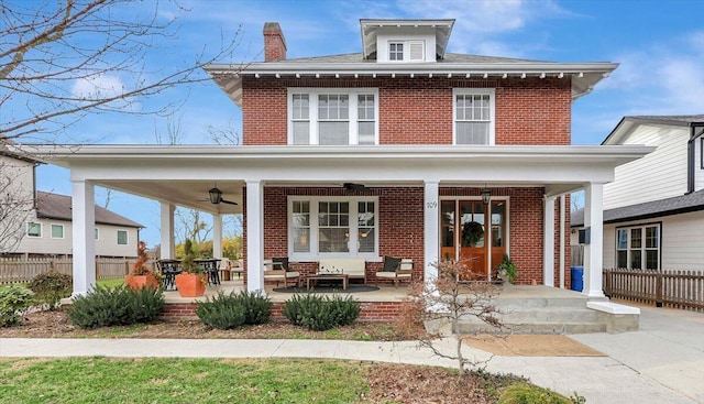 rear view of house with ceiling fan and a porch