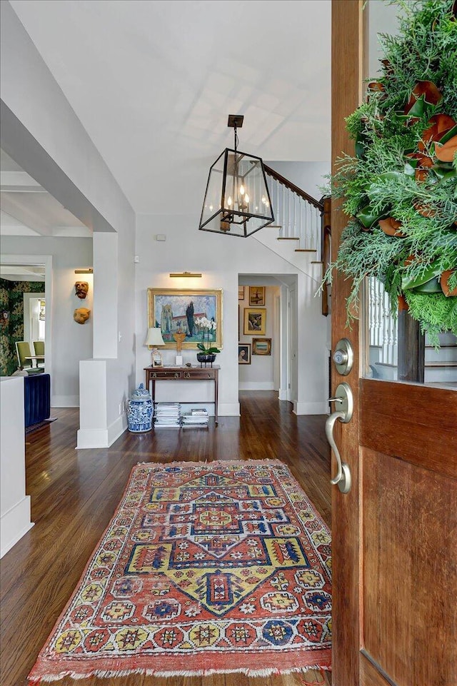 foyer entrance featuring dark hardwood / wood-style flooring and a notable chandelier