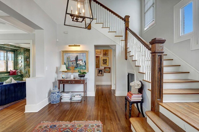 staircase with hardwood / wood-style flooring, a high ceiling, and a wealth of natural light