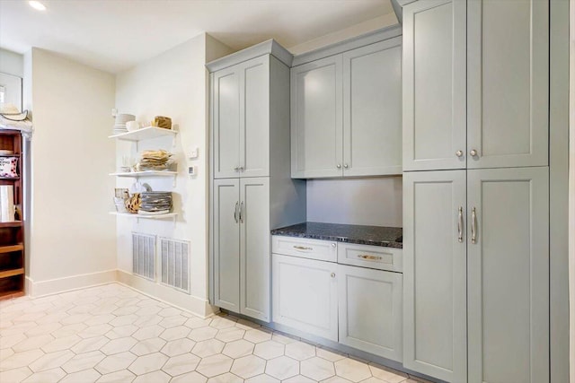 kitchen with gray cabinetry and dark stone countertops