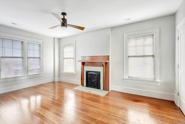 unfurnished living room with ceiling fan, plenty of natural light, and light hardwood / wood-style flooring