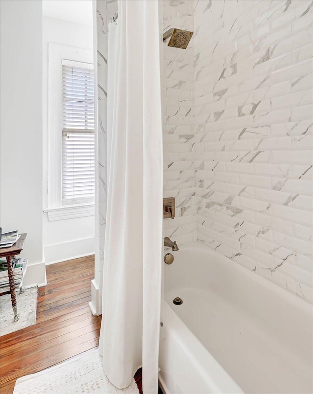 bathroom with wood-type flooring and shower / bath combo