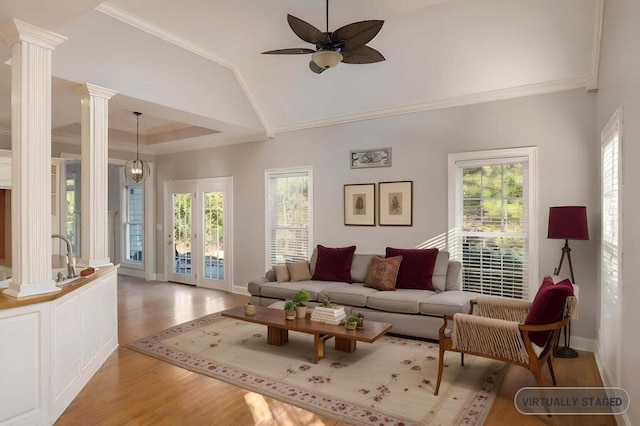 living room featuring decorative columns, crown molding, plenty of natural light, and hardwood / wood-style floors