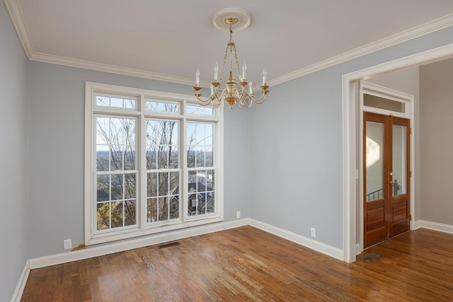 unfurnished dining area featuring ornamental molding, hardwood / wood-style floors, and a notable chandelier