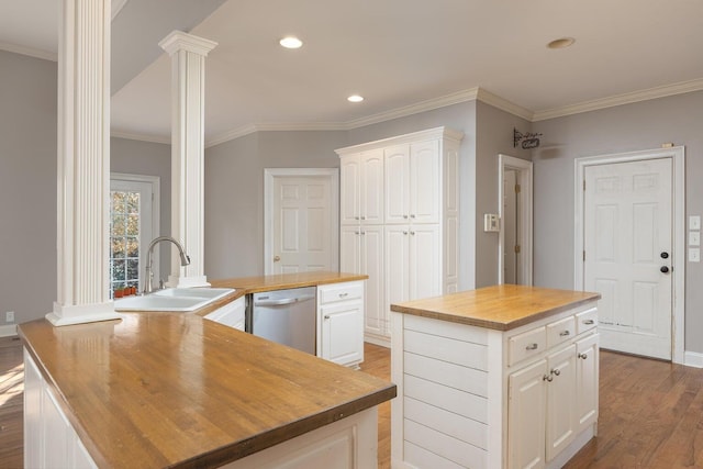 kitchen with ornate columns, white cabinetry, wooden counters, stainless steel dishwasher, and a kitchen island