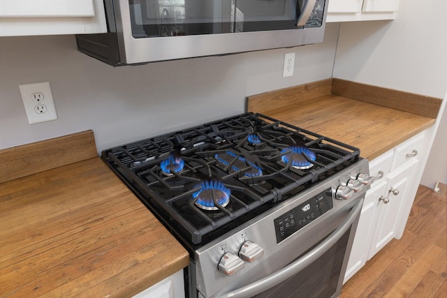 kitchen featuring white cabinetry, appliances with stainless steel finishes, and light hardwood / wood-style flooring