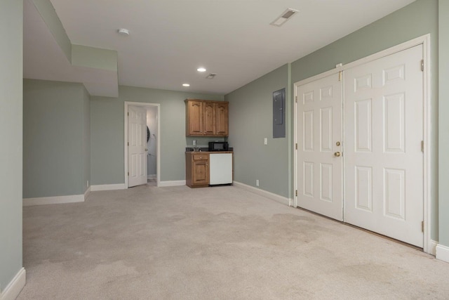 unfurnished living room with light colored carpet and electric panel