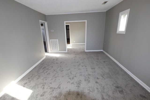 unfurnished room with carpet floors and a textured ceiling