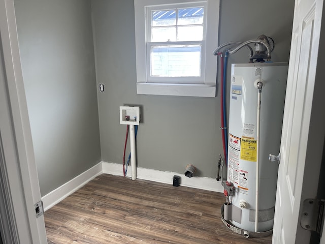 clothes washing area with dark hardwood / wood-style flooring, hookup for a washing machine, and gas water heater