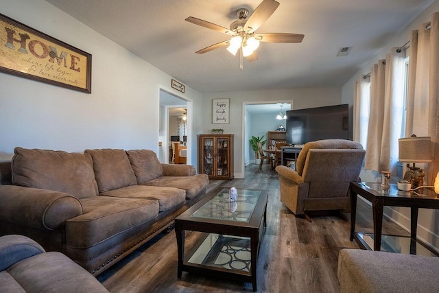 living room featuring ceiling fan and dark hardwood / wood-style flooring