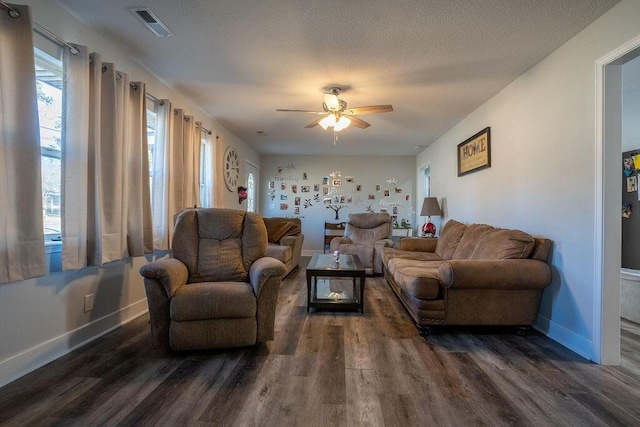 living room with ceiling fan, dark wood-type flooring, and a textured ceiling