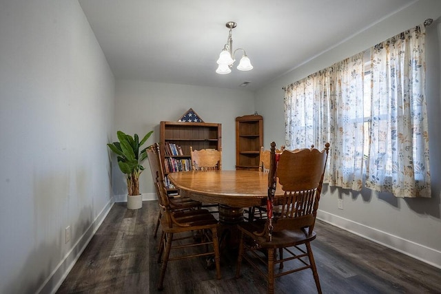 dining area with dark hardwood / wood-style floors and a chandelier