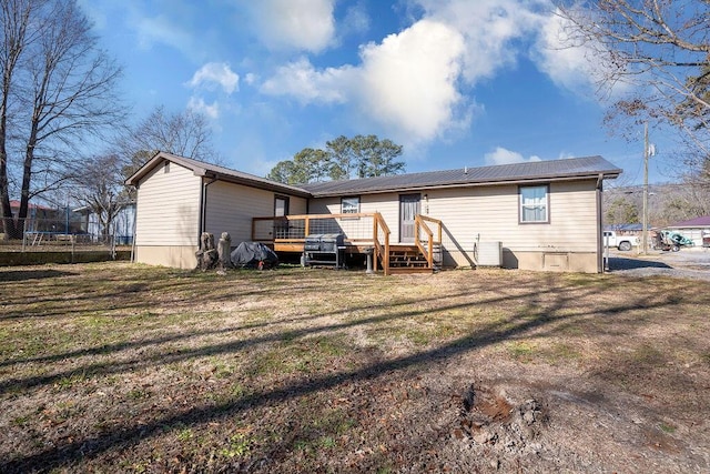 back of property with a yard and a deck