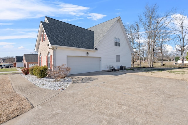 view of side of home featuring central AC unit and a garage