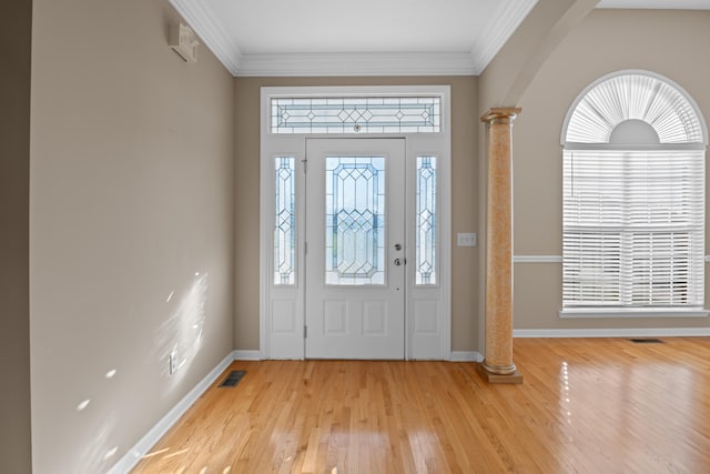 foyer entrance with light hardwood / wood-style flooring, crown molding, and decorative columns