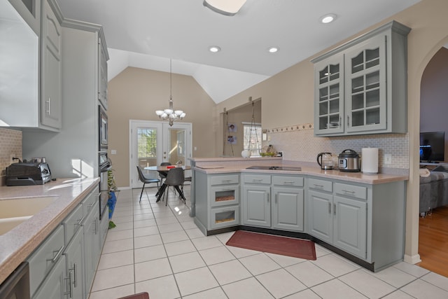 kitchen featuring gray cabinets, decorative light fixtures, light tile patterned floors, and lofted ceiling