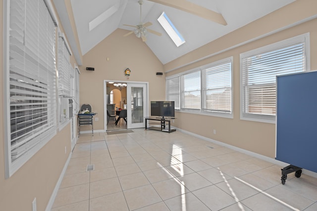 interior space featuring high vaulted ceiling, light tile patterned floors, ceiling fan, and a skylight