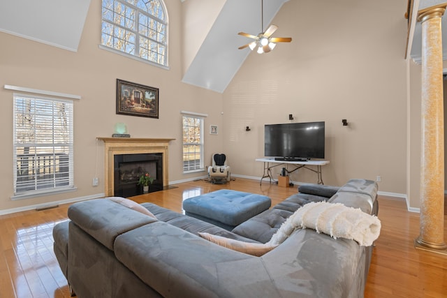 living room featuring light hardwood / wood-style floors, a wealth of natural light, and decorative columns