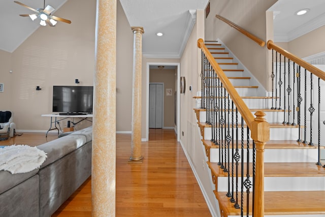 staircase with ornamental molding, ornate columns, ceiling fan, and wood-type flooring