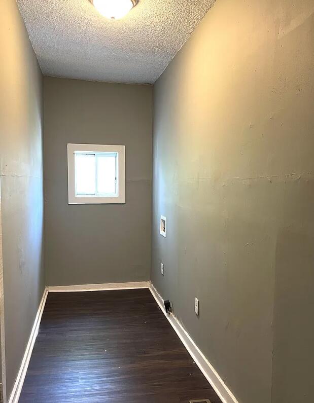 empty room featuring dark wood-type flooring and a textured ceiling