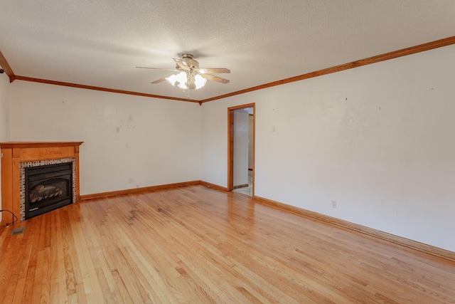 unfurnished living room featuring ceiling fan, ornamental molding, light hardwood / wood-style flooring, and a textured ceiling