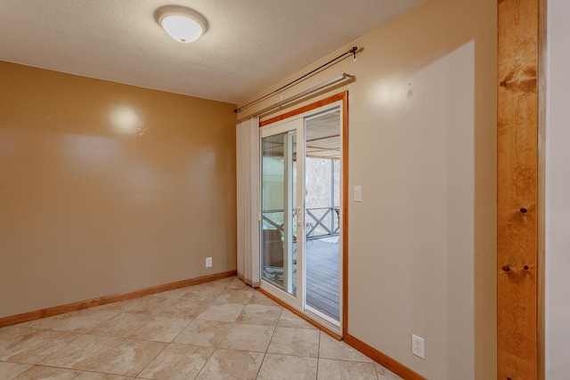 tiled empty room with a textured ceiling