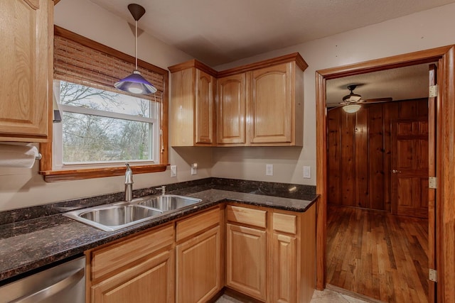 kitchen with sink, hanging light fixtures, stainless steel dishwasher, light hardwood / wood-style floors, and light brown cabinets