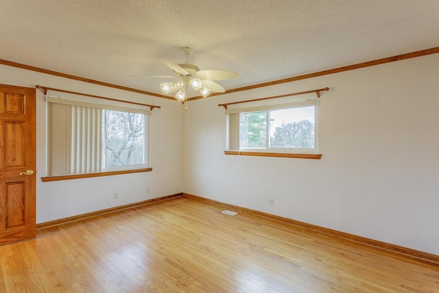 spare room with ornamental molding, ceiling fan, a textured ceiling, and light wood-type flooring