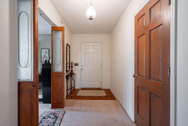 doorway with light colored carpet