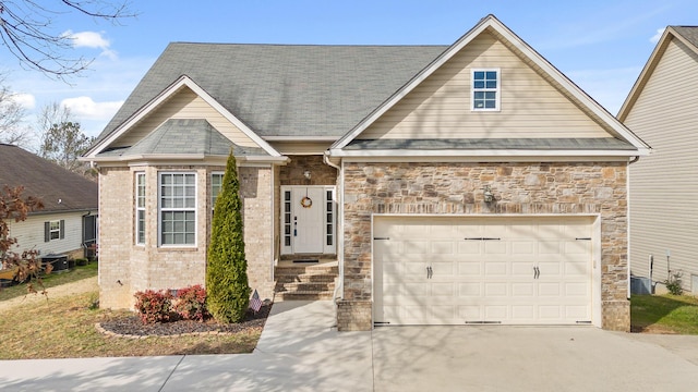 8500 Standifer Gap Rd, Chattanooga, TN 37421 - view of front of home with a shingled roof, concrete driveway, an attached garage, central AC, and stone siding