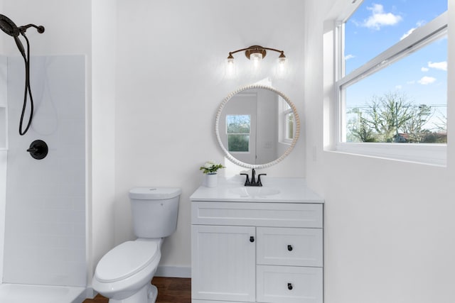 bathroom featuring vanity, toilet, and a shower