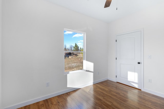 spare room featuring dark wood-type flooring and ceiling fan