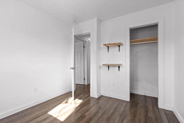 unfurnished bedroom featuring dark hardwood / wood-style floors and a closet