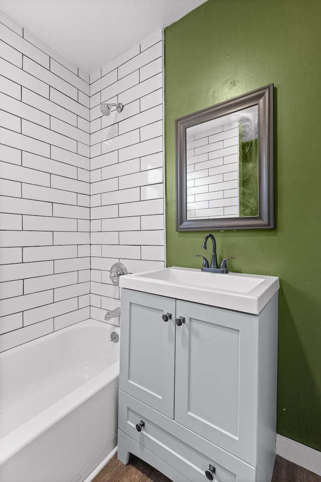 bathroom featuring tiled shower / bath combo, vanity, and hardwood / wood-style floors