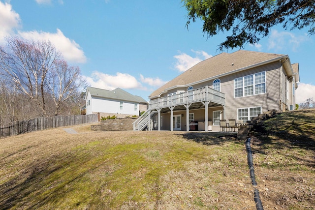 rear view of property with a lawn, a patio area, fence, a wooden deck, and stairs