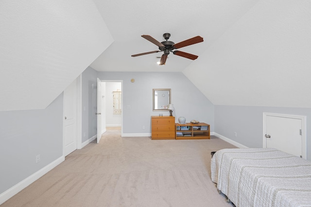 bedroom featuring ceiling fan, baseboards, vaulted ceiling, and light colored carpet