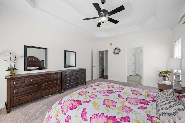 bedroom with baseboards, light colored carpet, ceiling fan, ornamental molding, and a tray ceiling