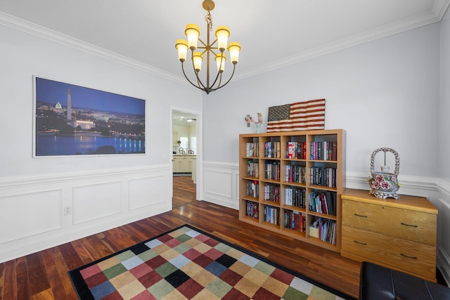 unfurnished room with a notable chandelier, ornamental molding, wood finished floors, and wainscoting