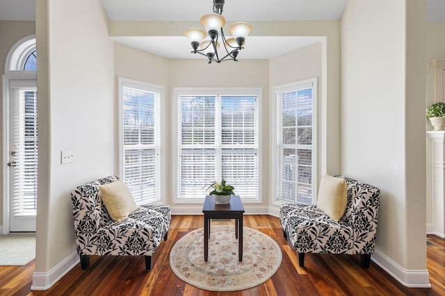 sitting room featuring an inviting chandelier, baseboards, and wood finished floors