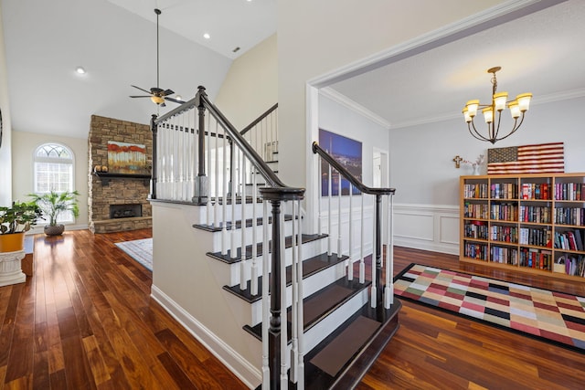 stairway with hardwood / wood-style flooring, a fireplace, crown molding, and a wainscoted wall