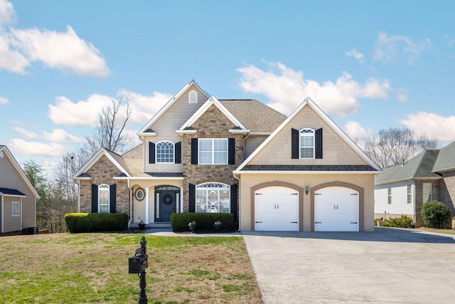 view of front of property with a garage, a shingled roof, driveway, stone siding, and a front yard