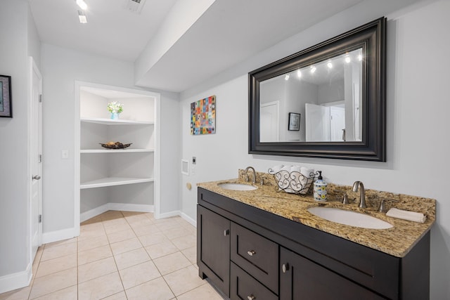 bathroom with baseboards, tile patterned floors, a sink, and built in features