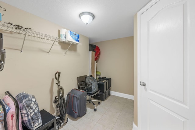 interior space with light tile patterned floors and baseboards