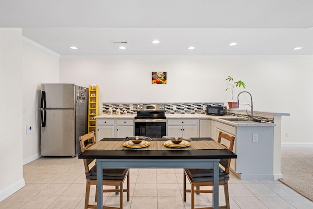 kitchen with stainless steel appliances, a sink, visible vents, ornamental molding, and backsplash