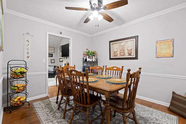 dining room featuring hardwood / wood-style flooring, crown molding, and a textured ceiling