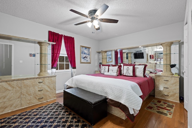 bedroom with dark wood-type flooring, ceiling fan, and a textured ceiling